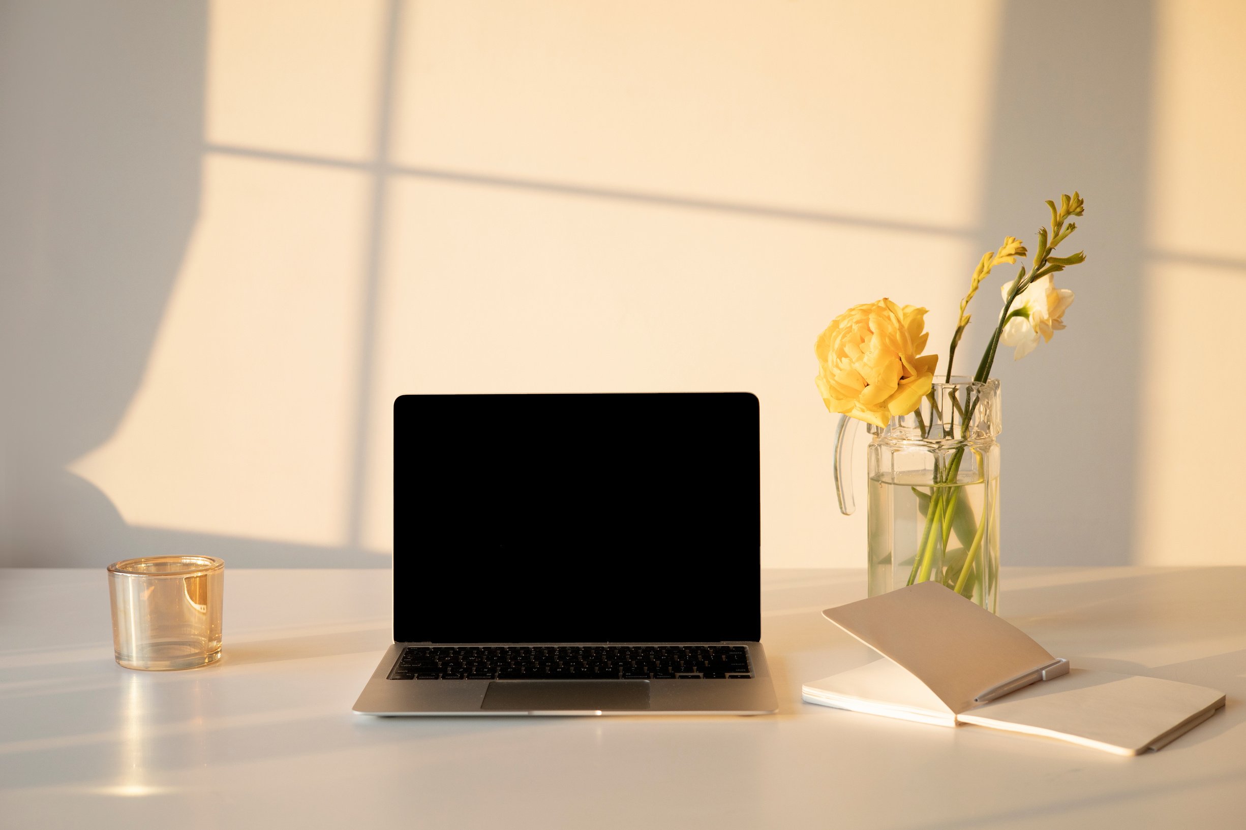 A Laptop beside a Notebook